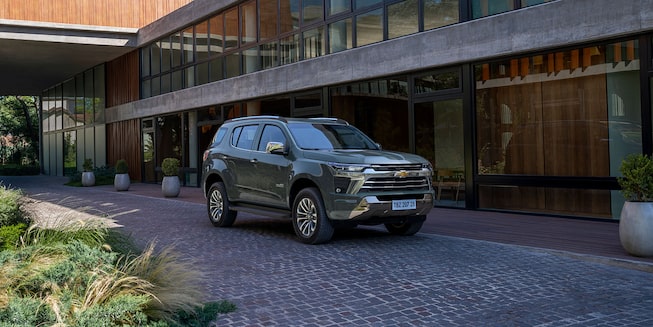 Imagem do novo SUV Chevrolet Trailblazer High Country, cinza topázio, estacionado em frente a uma casa.