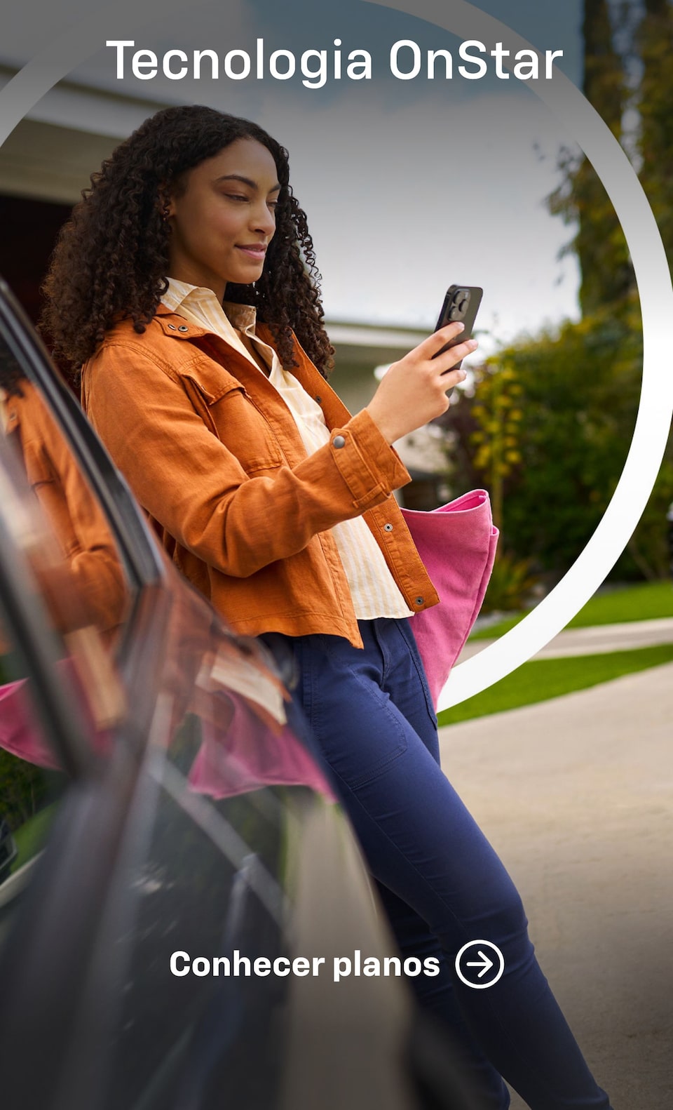 Imagem de uma mulher apoiada em um veículo Chevrolet enquanto usa o celular. Texto: Tecnologia Onstar - Conhecer planos.