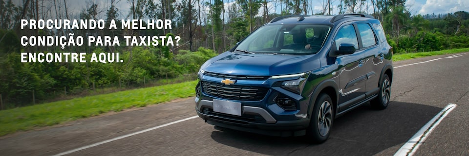 imagem do novo Chevrolet Spin na cor azul boreal, em movimento por uma estrada.