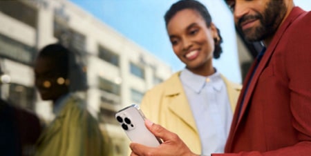 Imagem de um casal olhando para a tela de um celular, observando o serviço OnStar.