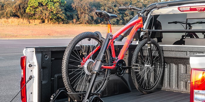 Imagem de uma bicicleta sobre o suporte de bike, dentro da caçamba da nova picape Chevrolet Silverado.